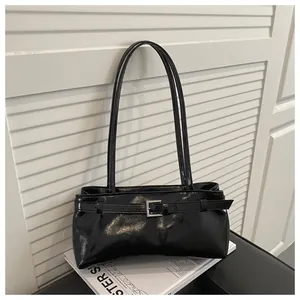 Gros plan du sac porté épaule vintage en cuir ciré noir brillant avec boucle