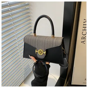 Dettaglio borsa a tracolla in pelle nera con patta in tweed e fibbia dorata logo M