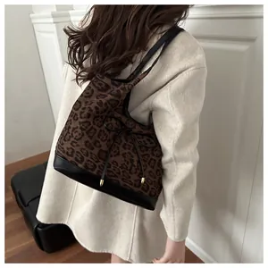 Detail of leopard print tote bag with black leather base and delicate bow decoration
