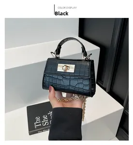 Detail of a mini black faux crocodile leather bag featuring a gold twist lock and chain strap