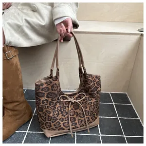 Close-up of leopard print tote bag with bow detail and premium leather handles