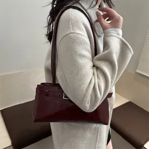 Sac baguette minimaliste bordeaux en cuir ciré brillant avec boucle argentée élégante