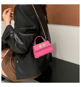 Close-up of fuchsia crocodile pattern mini bag with gold twist lock and chain strap