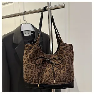 Close-up of leopard print tote bag with black leather bow and reinforced bottom panel