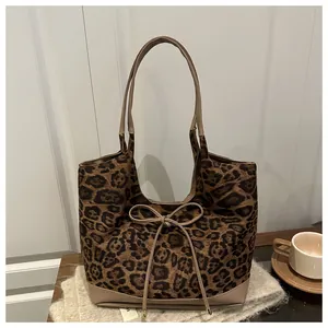 Detail of leopard print tote bag with suede texture and decorative bow drawstring