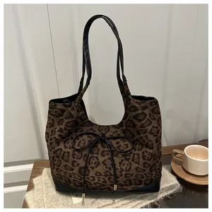 Close-up of leopard print tote bag with black bow decoration and faux leather trim