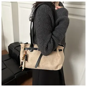 Detail of vintage matte suede handbag with wood bead charm and black leather straps