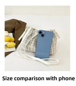 Detail view of tweed crossbody bag with gold thread and size comparison to a phone