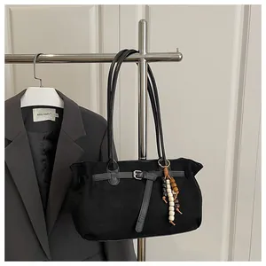 Detail of vintage matte black suede tote bag with beaded charm and metal buckle strap