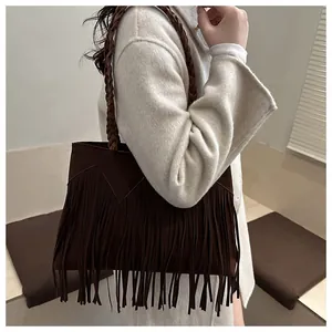 Détail du sac bandoulière à franges en daim marron avec bandoulière tissée main