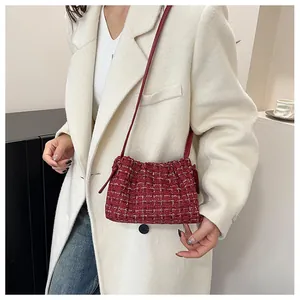 Detail of red tweed drawstring shoulder bag with golden threads on white blazer