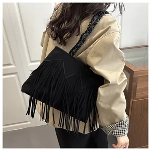 Détails de la bandoulière en cuir tressé et des longues franges sur le sac bohème en daim