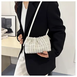 Chic tweed shoulder bag detail on model featuring soft cloud-like pleats and cream fabric