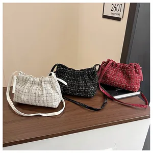 Detailed close-up of three tweed crossbody bags in cream, black, and wine red colors