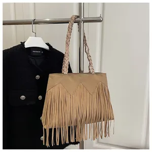 Gros plan d'un sac cabas bohème kaki avec de longues franges et des anses tissées
