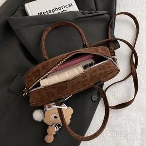 Macro detail of brown suede Boston bag interior showing spacious capacity for phone and wallet