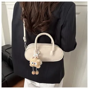 Detail view of off-white baguette bag with brown plush charm on striped blazer