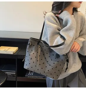 Vue détaillée d'un sac cabas en tissu gris avec pois noirs et broderies fines