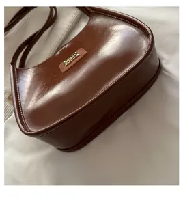 Detailed side view of brown oiled leather shoulder bag showing smooth texture and stitching