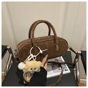Detail of dark brown leopard print boston bag with silver zipper and plush charm