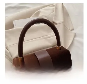 Detail of soft brown suede stitching and elegant golden buckle on a fashion handbag