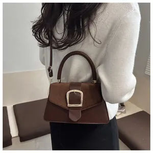 Detail of brown leather and suede contrast shoulder bag with a gold square buckle