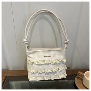 Detail der Creme-Spitzenrüschen und Karo-Muster auf eleganter Damen Schultertasche