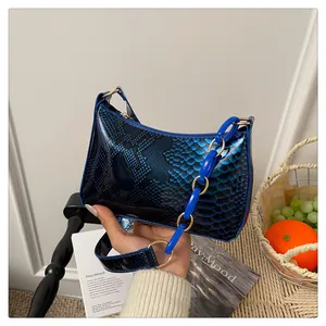 Gros plan du sac à bandoulière bleu à motif serpent avec grosse chaîne en plastique