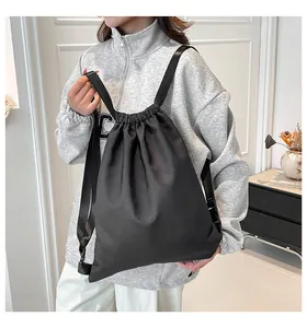 Details eines schwarzen Nylon-Rucksacks mit Kordelzugverschluss und breiten Riemen