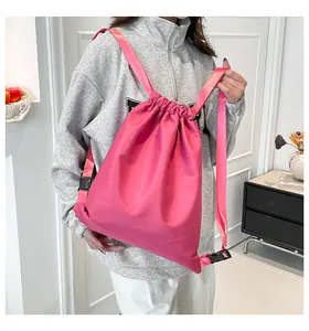 Detail des pinkfarbenen Nylon-Rucksacks mit Kordelzug, wasserfestem Stoff und Trägern