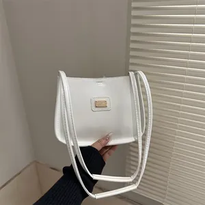 Minimalist white faux leather underarm bag with gold metal plate and dual straps