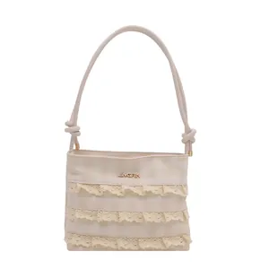 Elegante cremefarbene Schultertasche mit Karomuster, Spitzenbesatz und geknotetem Riemen