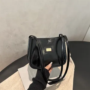 Minimalist black patent leather underarm shoulder bag with elegant gold hardware