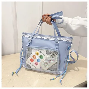 Close-up of light blue canvas tote with lace trim, bead drawstring, and clear PVC window