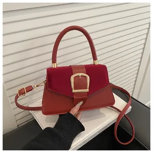Detail of vintage red crossbody bag with suede patchwork and large gold square buckle