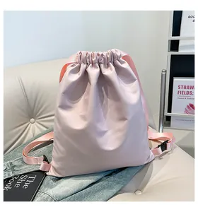 Detail eines rosa Kordelzug-Rucksacks aus glänzendem Nylon mit verstellbaren Trägern