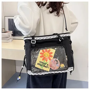 Detail of black canvas ita bag with clear PVC window and white lace trim on a model
