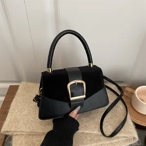 Elegant black leather patchwork crossbody bag with large gold buckle and handle