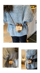 Dettaglio mini borsa a tracolla in pelle scamosciata con fiocco 3D e ciondolo orsetto