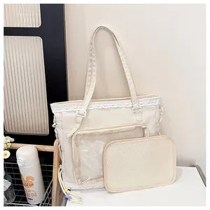 Detail of cream canvas ita bag with transparent PVC window and white lace trim edge