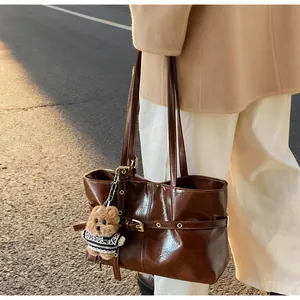 Sac cabas vintage en cuir ciré marron avec boucles et porte-clés ours à l'épaule