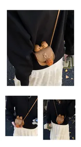 Dettaglio mini borsa a tracolla in pelle scamosciata marrone con orsetto e fiocco