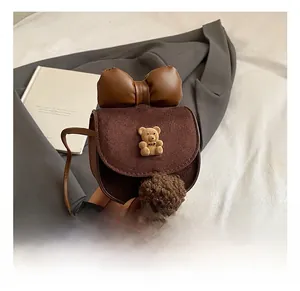 Dettaglio mini borsa scamosciata con fiocco in pelle marrone e orsetto 3D decorativo