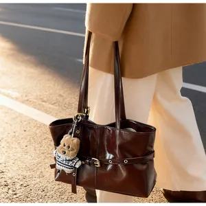 Détail du grand sac cabas en cuir ciré marron avec boucle métal et charm petit chien