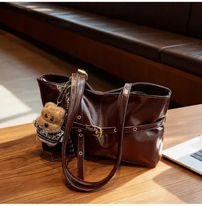 Détail du sac cabas marron foncé en cuir ciré avec texture douce et charmant pendentif