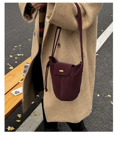 Vue détaillée du sac seau bordeaux mat avec accents dorés et cordon de serrage