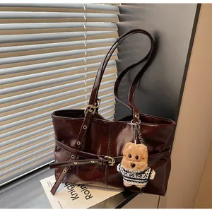 Détail du grand cabas en cuir ciré marron foncé brillant avec charm ours mignon