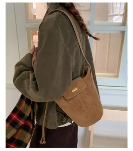 Close-up of vintage brown frosted bucket bag with gold buckle and shoulder strap