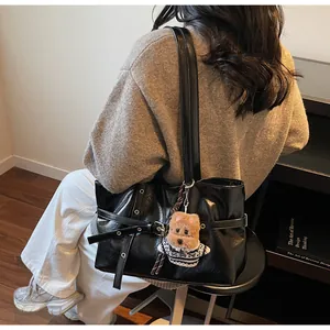 Détail du grand sac cabas noir brillant avec boucle en métal et charmant petit chien en peluche