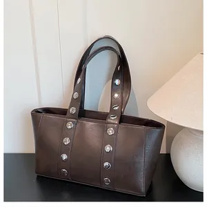 Detailed view of silver metallic studs on a premium dark brown leather tote shoulder bag